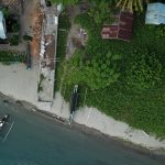 Drone shot capturing a coastal scene with boats and greenery in Una-Una, Indonesia.